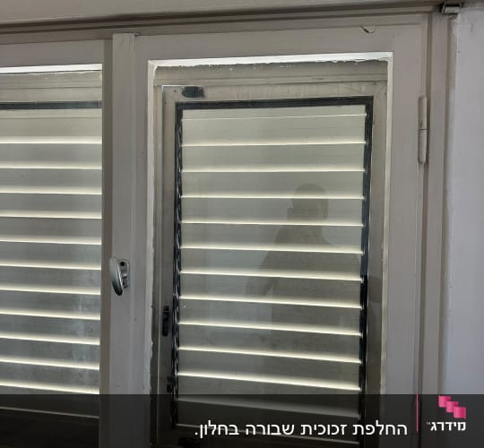 חלון עם תריסים סגורים ומסגרת עץ